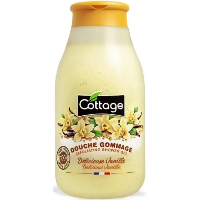 Gel douche gommage Cottage (270ml de pure gourmandise) Un flacon de gel douche gommage Cottage "Délicieuse Vanille", contenant des grains naturels, sur fond blanc.