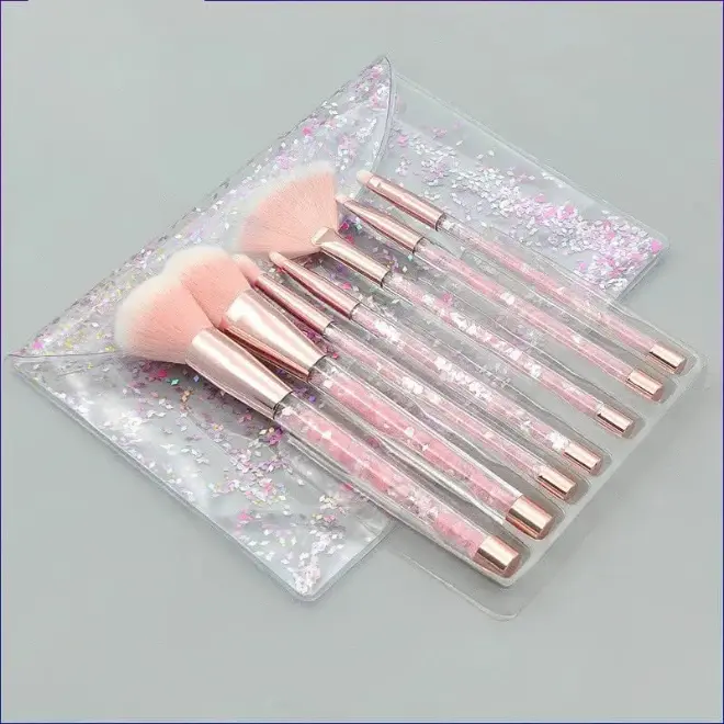 Trousse Pinceaux Maquillage 7 Pièces (Effet Crystal et Paillettes) Trousse de 7 pinceaux de maquillage avec des manches transparents remplis de paillettes roses et blanches, dans une pochette.