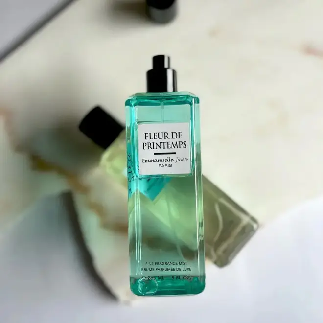 Parfum Emmanuelle Jane : 5 secrets pour une brume de luxe (Fleur de Printemps) Une brume parfumée de luxe "Fleur de Printemps" d'Emmanuelle Jane, dans un flacon rectangulaire teinté de turquoise et de vert.