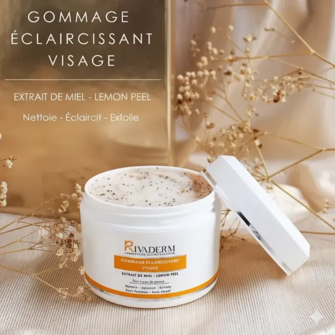 RIVADERM Gommage Éclaircissant Visage 150 ml (3‑en‑1 Éclat) Gommage visage RIVADERM au miel et citron, pot ouvert, texture crémeuse aux grains, décor fleurs séchées sur tissu doux