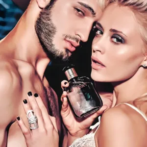 Couple glamour tenant un flacon de Whisky Silver 100ml. Image publicitaire illustrant un homme magnétique et charismatique.