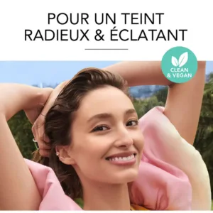 Mannequin souriant en extérieur, teint radieux. Produit Bourjois Clean & Vegan pour un teint éclatant.