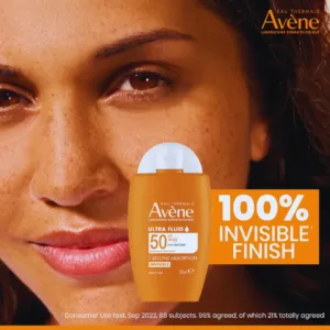 Gros plan sur le visage souriant d'une femme à la peau mate tenant le solaire Avène Ultra Fluid SPF 50+. Promesse : 100% Invisible.