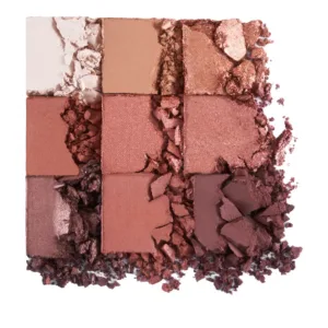 Gros plan artistique sur les 9 fards à paupières de la palette Flormar N°003, brisés et éparpillés, révélant la pigmentation poudreuse.