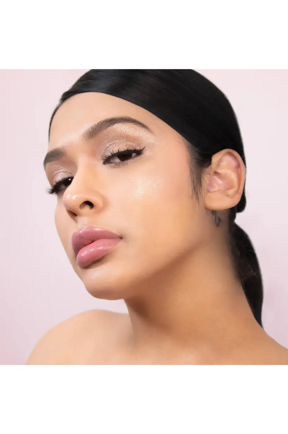 Éclat Lumineux : Maquillage Scintillant Femme avec maquillage lumineux, fard à paupières pailleté, lèvres roses, teint éclatant, possiblement Flormar Highlighter Illuminator N°002.