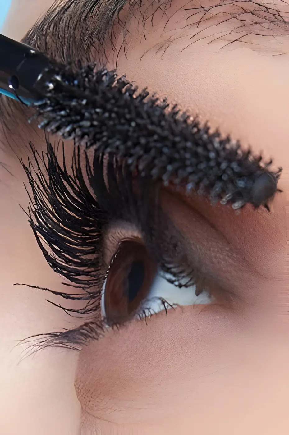 L’Instant Magique : Application du Mascara Sky High Application du mascara Maybelline Sky High Noir sur des cils longs et volumineux. Gros plan sur la brosse flexible et l'œil marron.