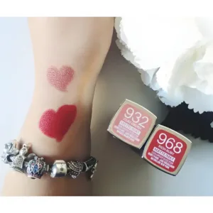 Deux cœurs de rouge à lèvres mats (rose poudré et rouge intense) sur un bras portant un bracelet Pandora, à côté de leurs packagings.