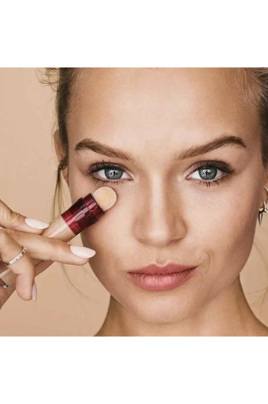 Application sous l’œil Application du correcteur Maybelline Instant Age Rewind sous l’œil, révélant une texture fluide et un fini naturel.