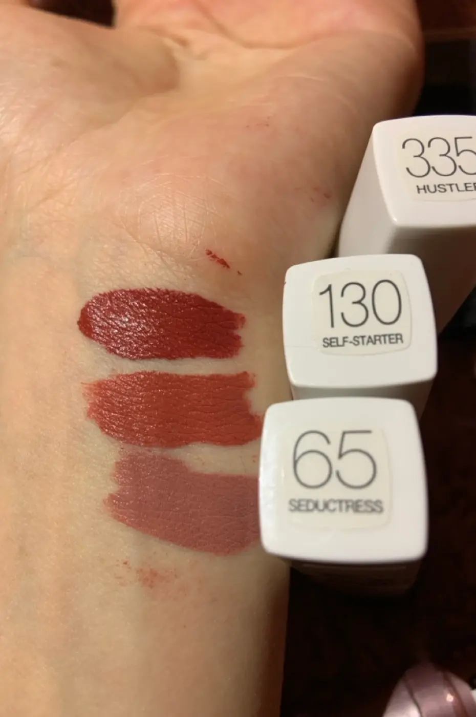 Comparatif Swatch : Matte Ink 65 Seductress et autres Échantillons des rouges à lèvres Maybelline Super Stay Matte Ink sur la peau, incluant le N°65 Seductress (nude rosé) et d'autres teintes.