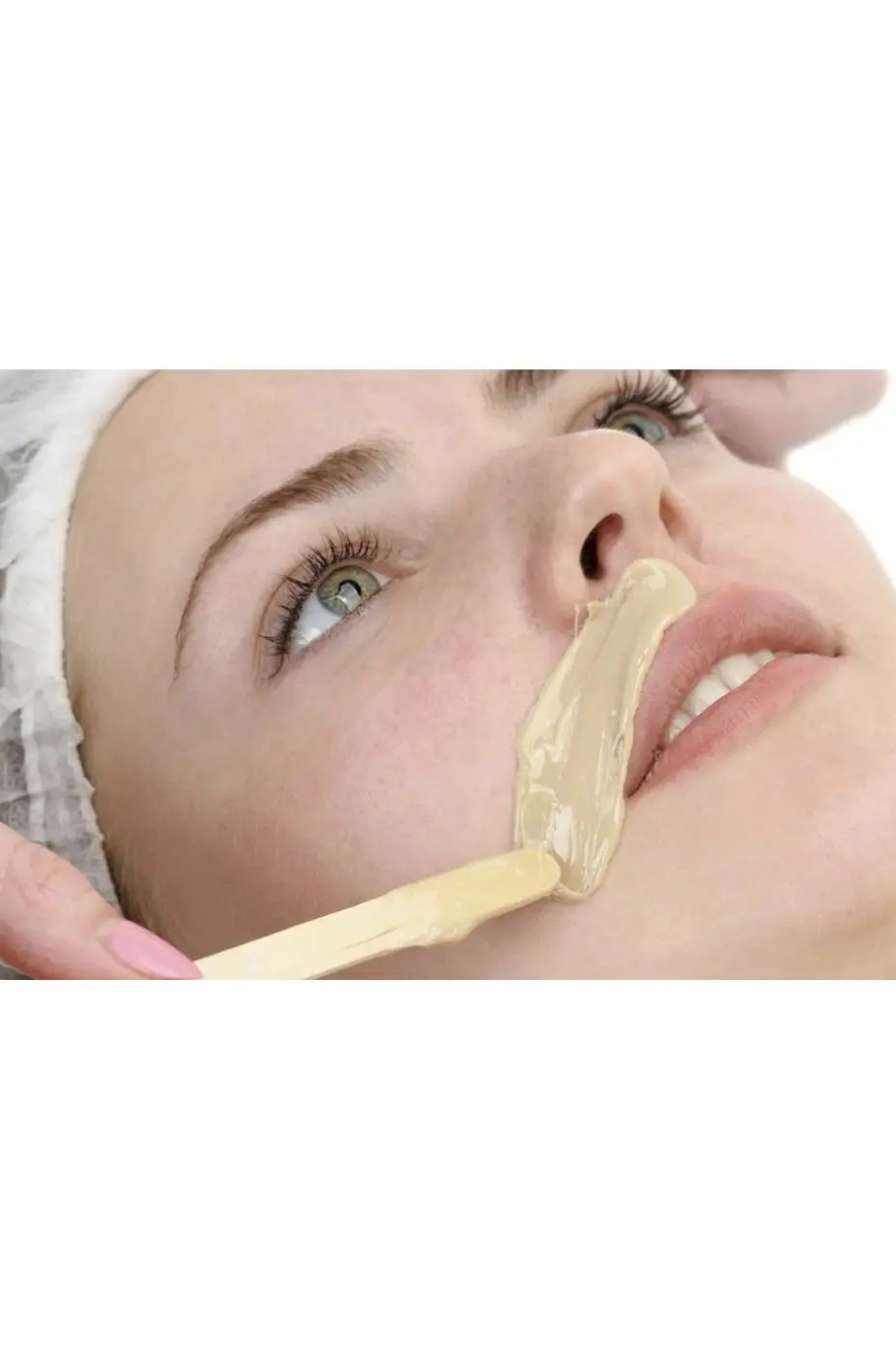 Épilation lèvre supérieure Femme recevant une épilation de la lèvre supérieure avec de la cire chaude appliquée par une esthéticienne.