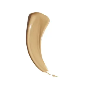 Échantillon de maquillage couleur beige-moyen sur fond blanc. La texture est lisse et crémeuse, en forme de virgule.