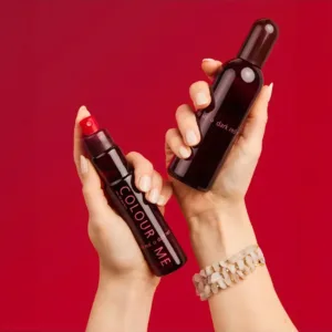 Deux mains tenant deux flacons de parfum Dark Red (100ml et format de voyage). Produit cosmétique sur fond rouge vif.