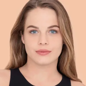 Portrait d'une femme avec un teint unifié et éclatant grâce au Correcteur Maybelline Fit Me N°10 (Ivoire).