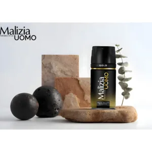 Déodorant Malizia Uomo Gold sur un socle en pierre naturelle avec éléments décoratifs minéraux et branche d'eucalyptus.