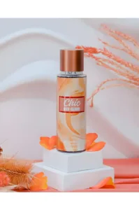 Brume parfumée Rimita Chic and Glam, flacon 200ml orange sur socle blanc avec pétales et fleurs séchées.
