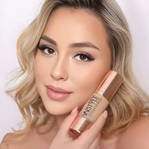 Femme blonde tenant le fond de teint Topface Instyle Perfect Coverage près de son visage au maquillage naturel et lumineux.