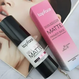 Flacon de base de teint Topface Skin Editor posé à côté de son étui rose et blanc. Packaging élégant et informatif.