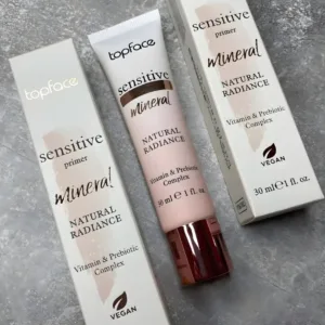Tube et emballage de la base Topface Sensitive Primer Mineral Natural Radiance 30ml avec logo Vegan sur fond gris texturé.