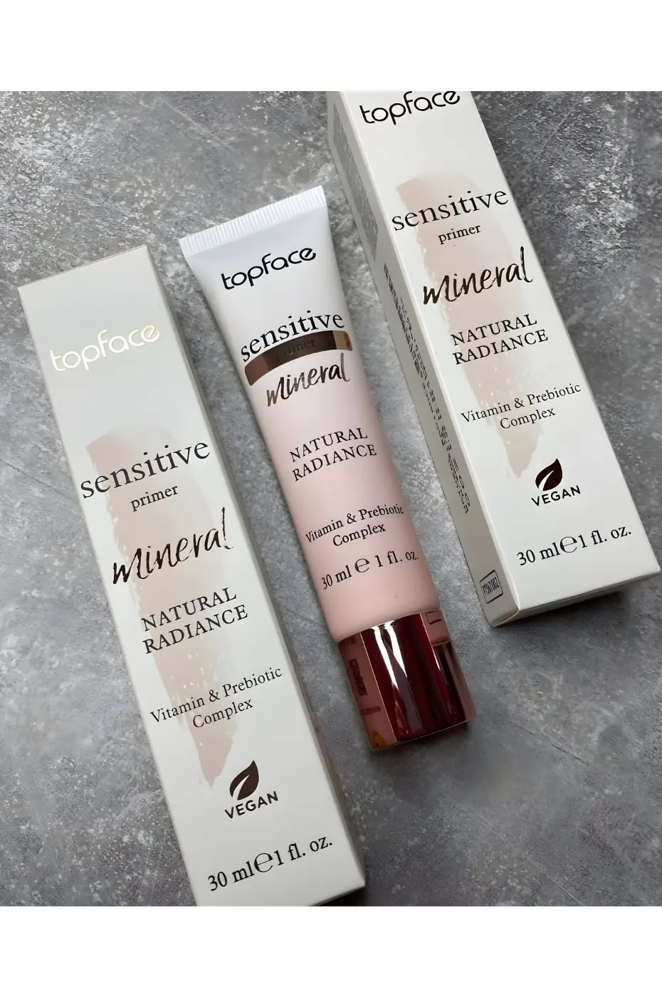 TOPFACE-SENSITIVE-PRIMER-N-002-1 Tube et emballage de la base Topface Sensitive Primer Mineral Natural Radiance 30ml avec logo Vegan sur fond gris texturé.