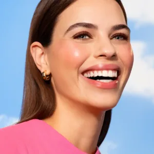 Femme souriante portant le blush Flormar 051 Dried Rose sur les pommettes pour un fini satiné et une peau lumineuse.