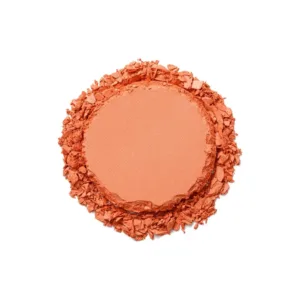 Blush poudre compact mat de couleur pêche abricot, texture pressée et émiettée sur fond blanc pour maquillage du teint.
