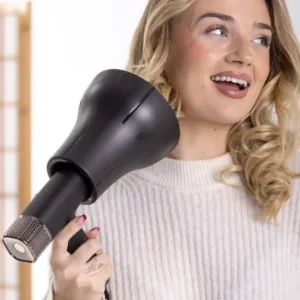 Une femme utilisant le diffuseur universel Eurostil noir pour définir ses boucles blondes de manière professionnelle.