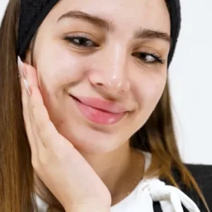 Une femme applique délicatement le gel-crème K-REINE sur son visage pour un nettoyage doux et nourrissant au karité.