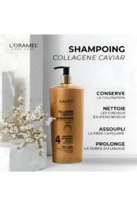 Flacon doré de shampoing L'Oramel Collagène Caviar 700ml posé près de fleurs blanches, illustrant un soin capillaire premium.