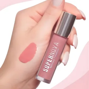 Main tenant le gloss Topface Supernova 002 avec un échantillon de la teinte rose Reimagine sur la peau.