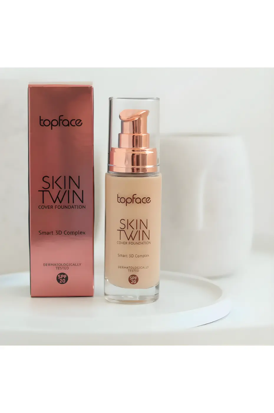 TOPFACE-INSTYLE-SKIN-TWIN-COVER-FDT-N-002-1 Flacon et boîte de fond de teint Topface Skin Twin Cover N°002, fini satiné et protection SPF 20 sur un plateau blanc.
