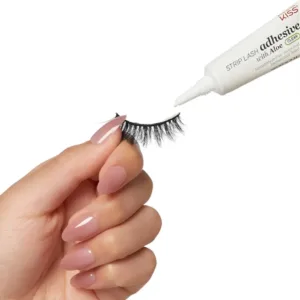Main appliquant l'adhésif Kiss Aloe Vera sur une bande de faux cils noirs avec l'embout de précision, sur fond blanc.