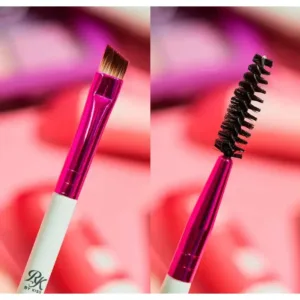 Gros plan sur les poils biseautés et la brosse goupillon du pinceau à sourcils Ruby Kisses, manche blanc et ferrule rose.