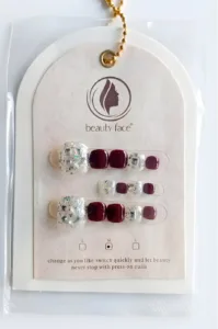 Kit press-on nails pieds Beauty Face bordeaux et argent pailleté avec strass. Ongles courts carrés sur carte de présentation.