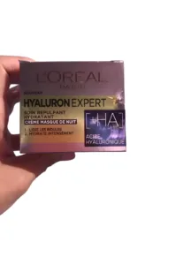 Boîte de crème de nuit L'Oréal Hyaluron Expert tenue à la main, soin hydratant à l'acide hyaluronique pour lisser la peau.
