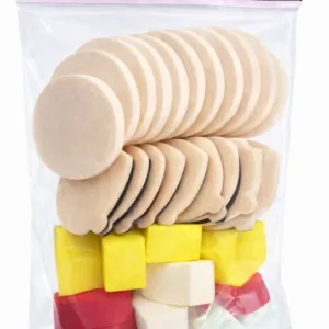 Sachet transparent Pollié : assortiment de 33 éponges beiges rondes et à bords profilés, avec blocs colorés en dessous.