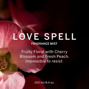 Affiche Love Spell de Victoria's Secret avec une fleur rose en gros plan sur fond noir et texte descriptif blanc.