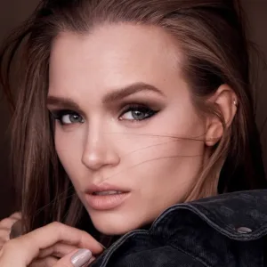 Portrait d'une femme au maquillage smoky eye noir intense et précis, mettant en valeur un regard audacieux et professionnel.