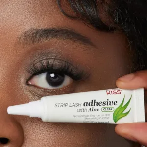 Œil avec faux cils volumineux et tube de colle Kiss Aloe Vera Clear tenu à la main pour montrer le résultat invisible.