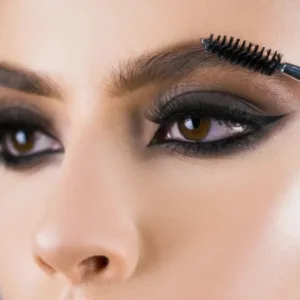 Mise en forme des sourcils avec le goupillon Pollié sur un maquillage des yeux intense pour un résultat naturel et net.
