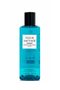 Flacon bleu de la brume parfumée Fleur Sauvage d'Emmanuelle Jane Paris sur fond neutre.