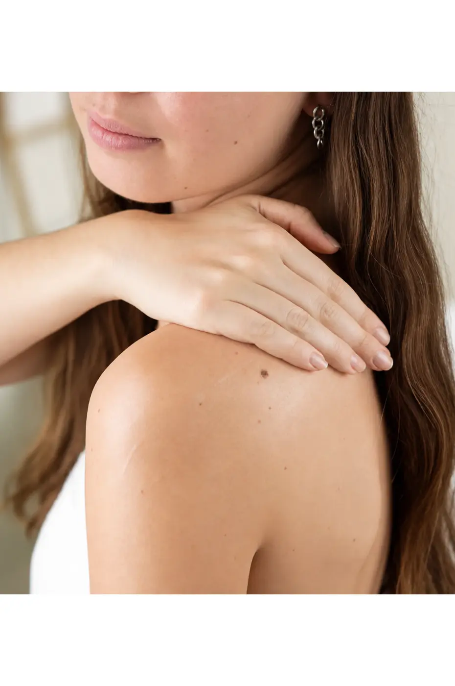 evoluderm-lait-corps-huile-precieuse-6 Femme appliquant le lait corps Evoluderm Huile Précieuse sur son épaule pour hydrater sa peau au quotidien.