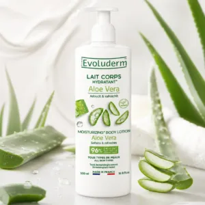 Flacon de lait corps hydratant Evoluderm Aloe Vera 500 ml entouré de tranches de plante fraîche et d'eau.